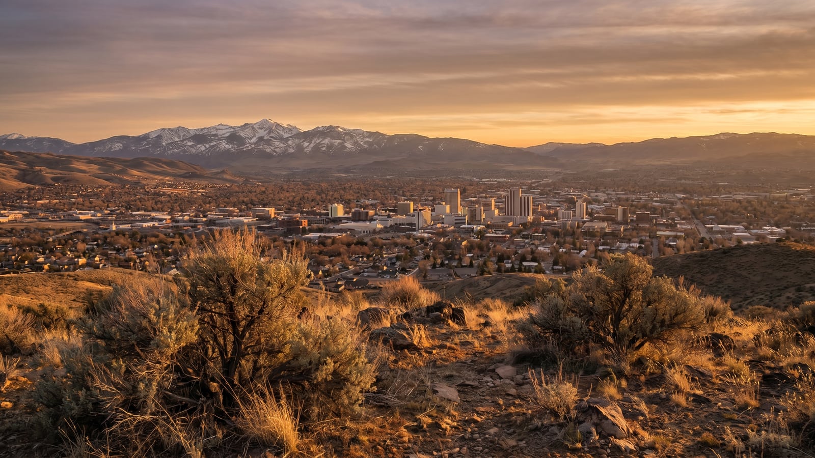 Reno, Nevada in its high-desert valley at golden hour with the Sierra Nevada mountains behind the skyline